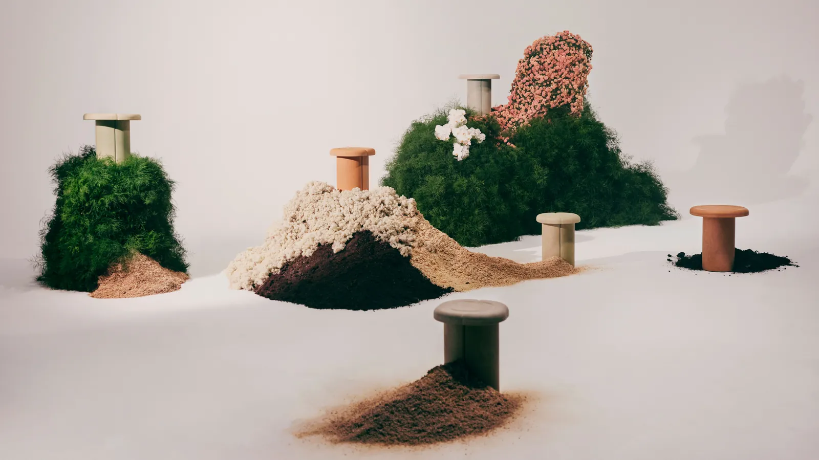 Tablas Alder de Patricia Urquiola para Mater (2024) sobre fondo gris claro: superficie con textura granulada del biomaterial Matek con cáscaras de café visibles, base metálica fina