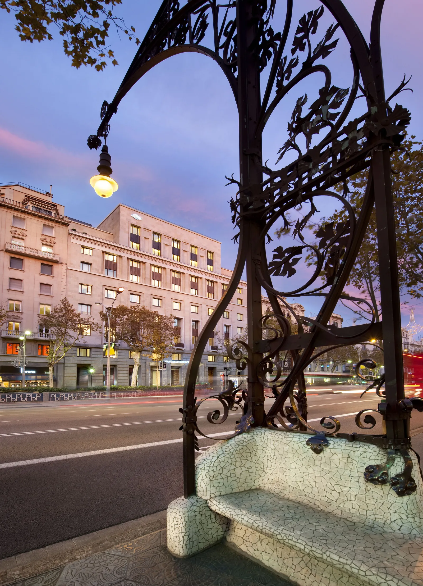 Mandarin Oriental Barcelona en Paseo de Gracia al atardecer: fachada neoclásica del antiguo Banco Hispano-Americano vista desde la calle con farola modernista catalana en primer plano