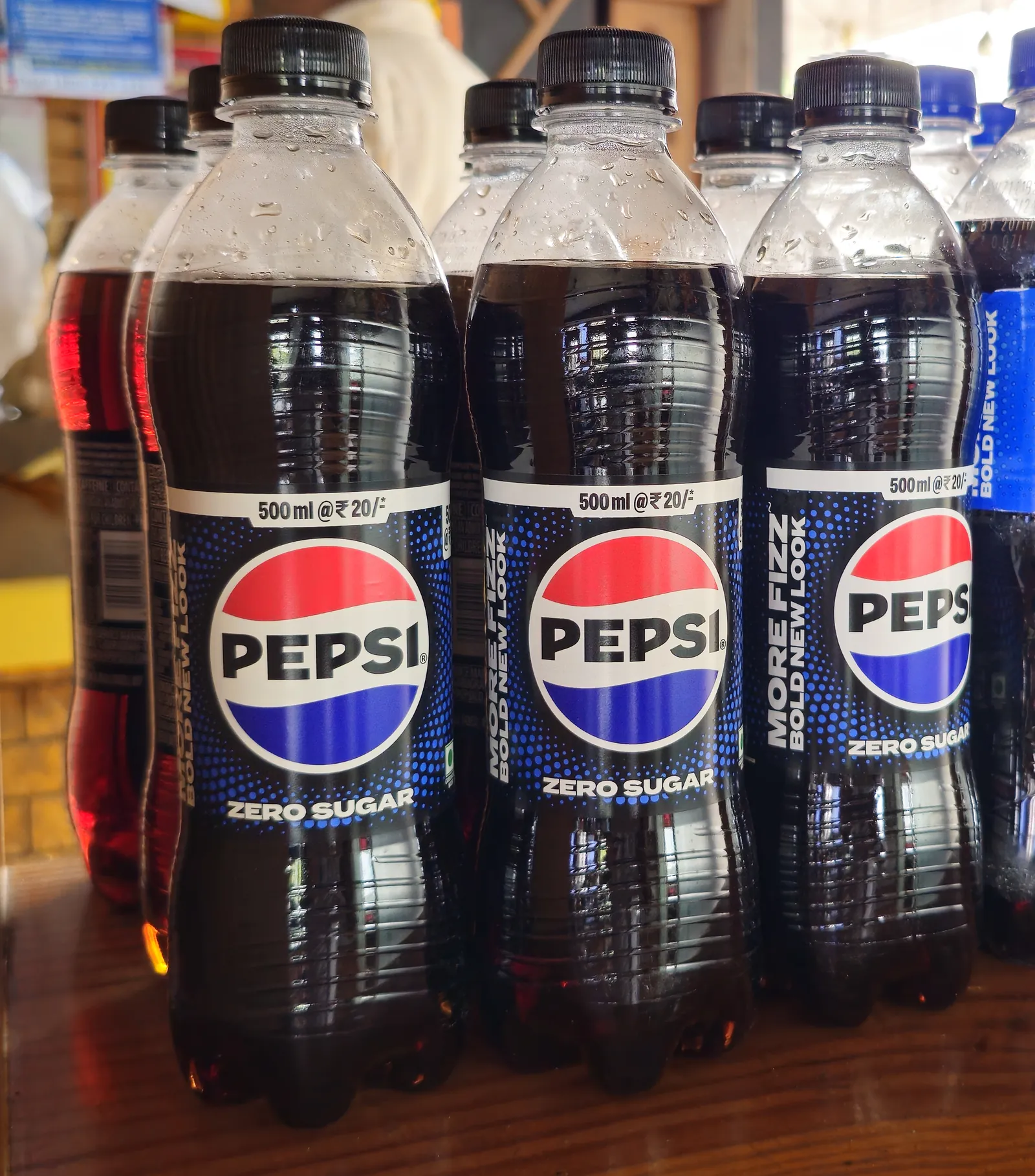 Tres botellas de Pepsi Zero Sugar de 500 ml con etiqueta negra, globo Pepsi restaurado al centro y leyenda 'MORE FIZZ BOLD NEW LOOK' en lateral